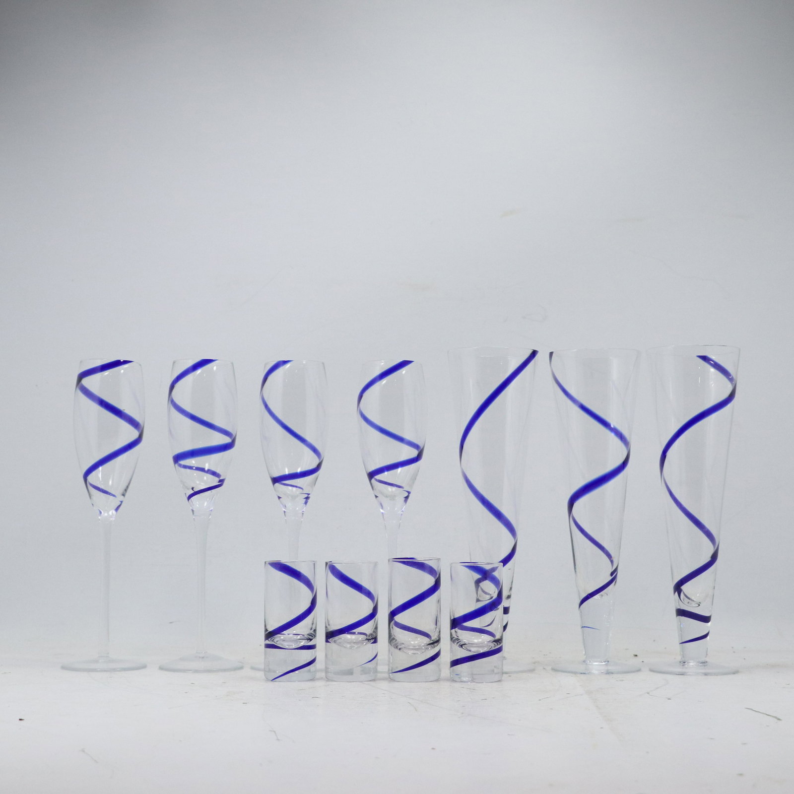 [11] Eleven Elegant Glass Cocktail Glasses with Spiral Blue Ribbon Design: [11] Eleven Elegant Glass Cocktail Glasses with Spiral Blue Ribbon Design. size: x4 tall 10h 2.75w x4 smlls 3.5h 1.5w x3 taller 10.25h 3w