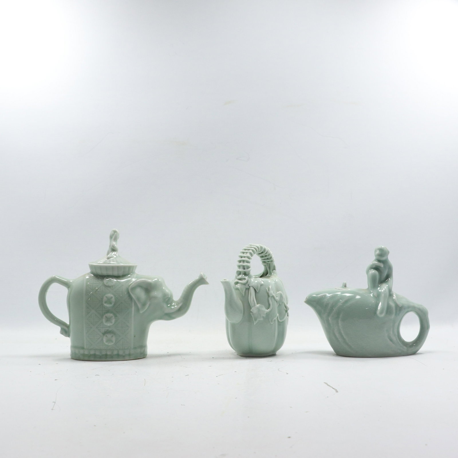[3] Three Green Celadaon Figurative Teapots, Pitchers: [3] Three Green Celadaon Figurative Teapots, Pitchers. size: elephant 7.5h 10w monkey 6.5h 7w basket pour 7h 5w