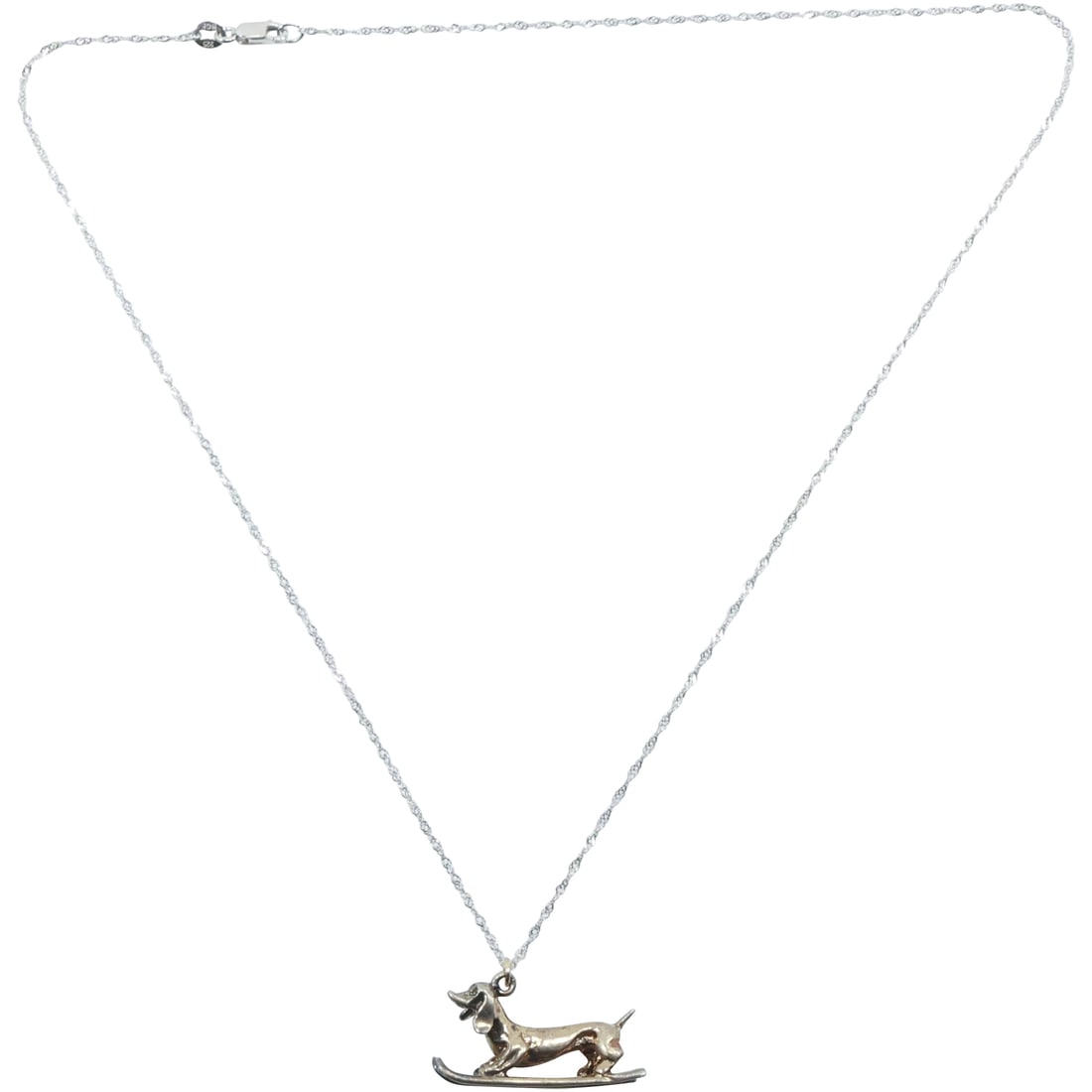 .925 Sterling Silver "Hound Dog Skiing" Charm Necklace on .925 Sterling 18 in. Chain: .925 Sterling Silver "Hound Dog Skiing" Charm 1 1/8 in. x 5/8 in. Necklace on .925 Sterling 18 in. Chain