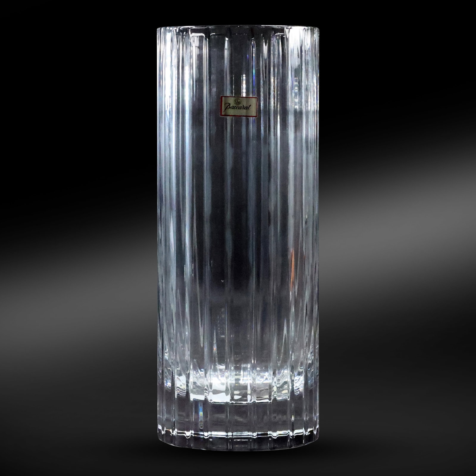 BACCARAT Discontinued Harmonie Clear Flower Vase: This exquisite Baccarat Harmonie clear flower vase is a stunning example of the timeless elegance and craftsmanship for which Baccarat is renowned. The Harmonie collection, known for its vertical line