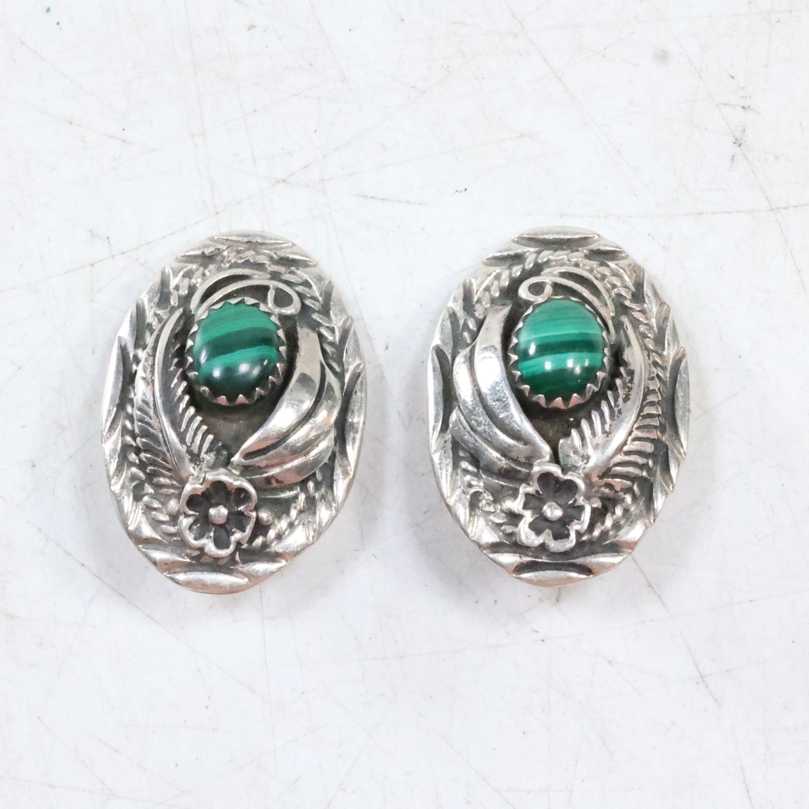 Vintage 1960s-70s Native American Sterling Clip-On Earrings with Malachite Center Stones: size: 1"x5/8" , Vintage 1960s-70s Native American Navajo Sterling Silver Clip-on Earrings. These earrings are sterling with a malachite center stone and a rosette and feather design.