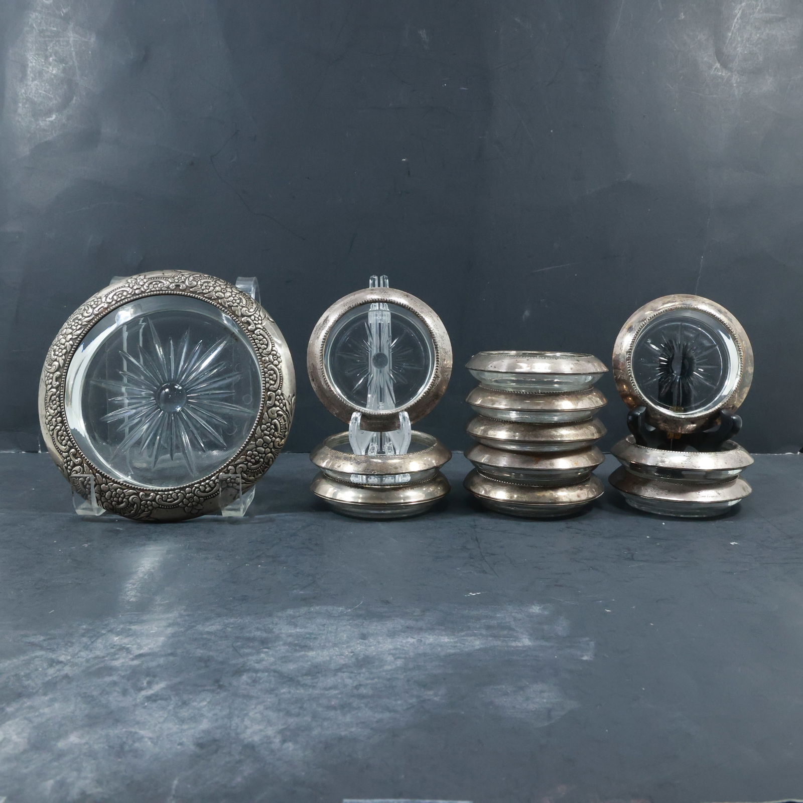 Frank M Whiting & Co Fancy Sterling Silver Rim Wine Bottle Coaster & 11 Sterling Rim Coasters: Frank M Whiting & Co Fancy Sterling Silver Rim Wine Bottle Coaster & 11 Sterling Rim Coasters. size: 3.75 in. x 1 in. (11x small), 6.75 in. x 1.75 in. (1x big) shelf: A