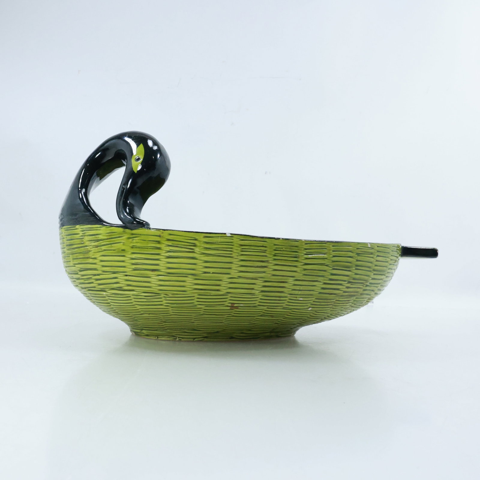 Bitossi Green Basket Weave Porcelain Duck Bowl 13 inches length: Bitossi porcelain bowl designed to resemble a duck. The bowl features a green basket weave pattern on its body, while the head and neck of the duck are black with yellow eyes. The overall shape of the