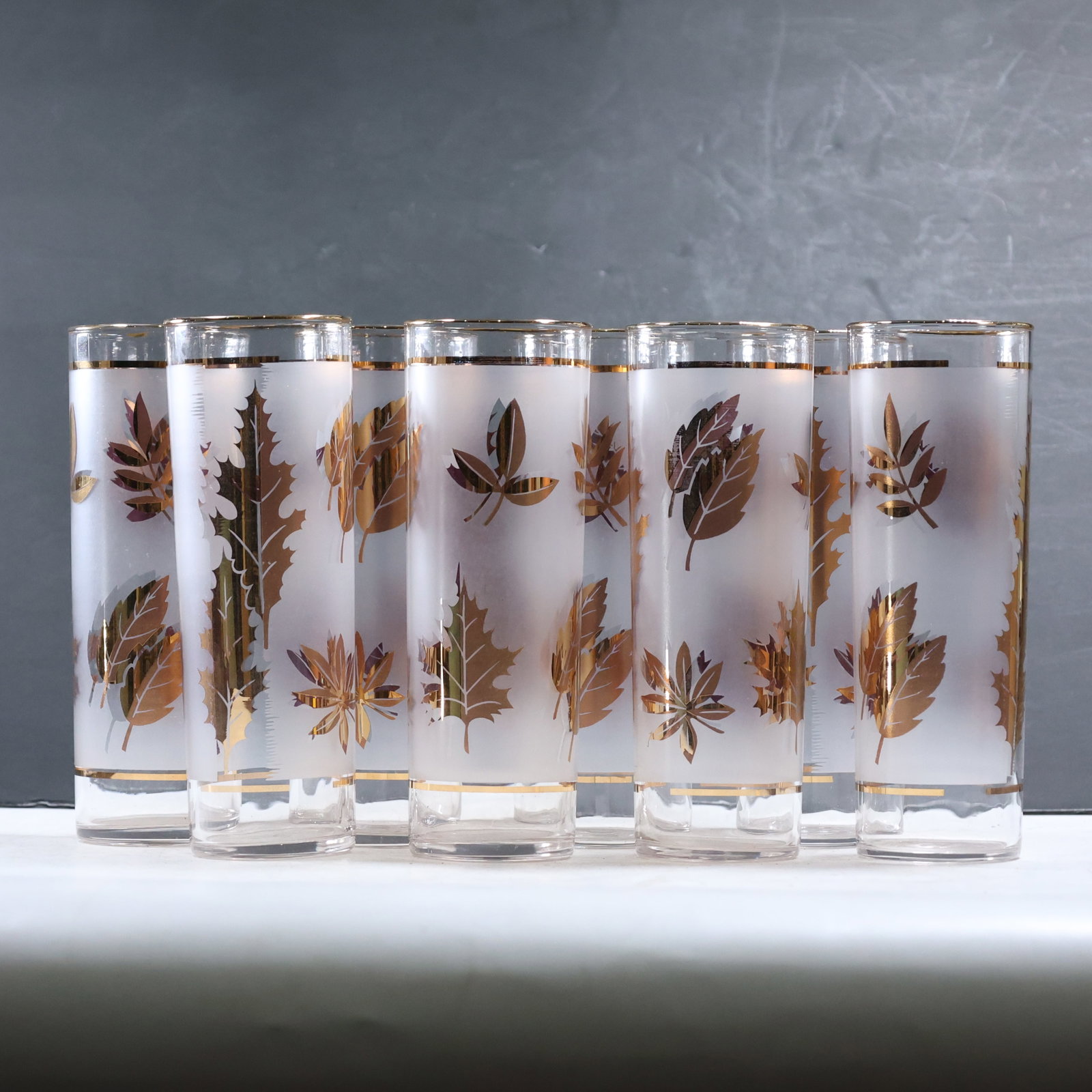 Set of 8 Libbey Mid Century Modern "Golden Foliage" Iced Tea Tumbler Glasses: 8 Libbey mid-century modern "Golden Foliage" iced tea tumbler glasses features a frosted glass body adorned with detailed golden leaf designs. Each tumbler showcases a variety of leaf patterns, adding