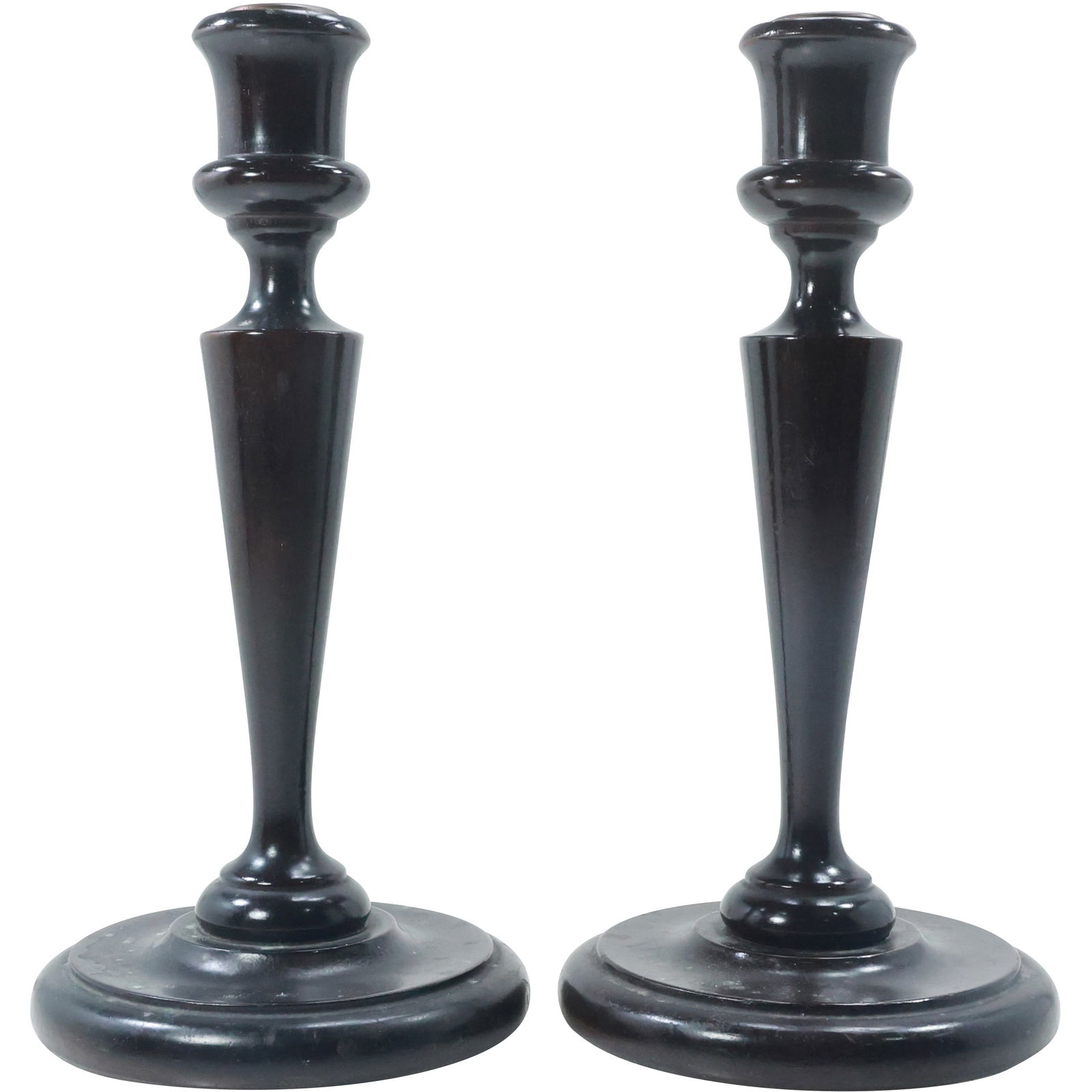 Antique Turned Wooden Candlesticks with Original Dark Finish: pair of antique turned wooden candlesticks, each standing 10 inches tall. They have a simple, traditional design with a smooth, tapered stem and a rounded base. The original dark finish has been prese