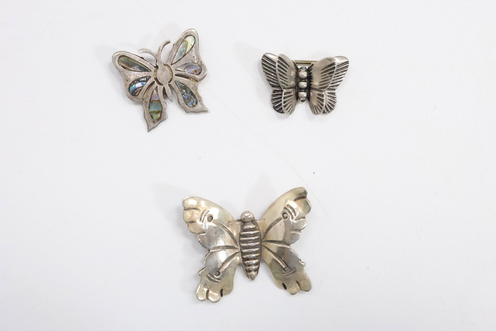 3 Assorted Sterling Silver Butterflies: Butterfly Pendant with Abalone Inlaid 7/8 in. dia.;: 3 Assorted Sterling Silver Butterflies: Butterfly Pendant with Abalone Inlaid 7/8 in. dia.; 940 Taxco Butterfly Pin 1 1/4 in. x 1 in.; Sterling Silver Double Wings Butterfly Pin 7/8 in. x 5/8 in.