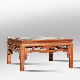 Chinese elmwood coffee table featuring an open fretwork design and an inset glass top. 36.5 in. dia.