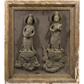 two Chinese Buddhist sculptures, likely bodhisattvas, carved from stone in high relief