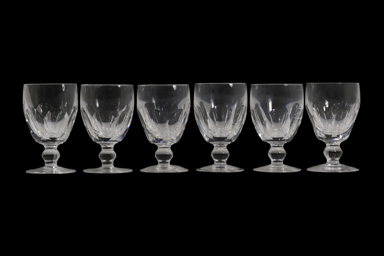 Set of Six Waterford Crystal Short Stem Goblets: Set of six signed Waterford crystal goblets, each featuring a short baluster stem and a rounded bowl with deeply cut vertical facets that catch and refract light. The glasses display the classic brill