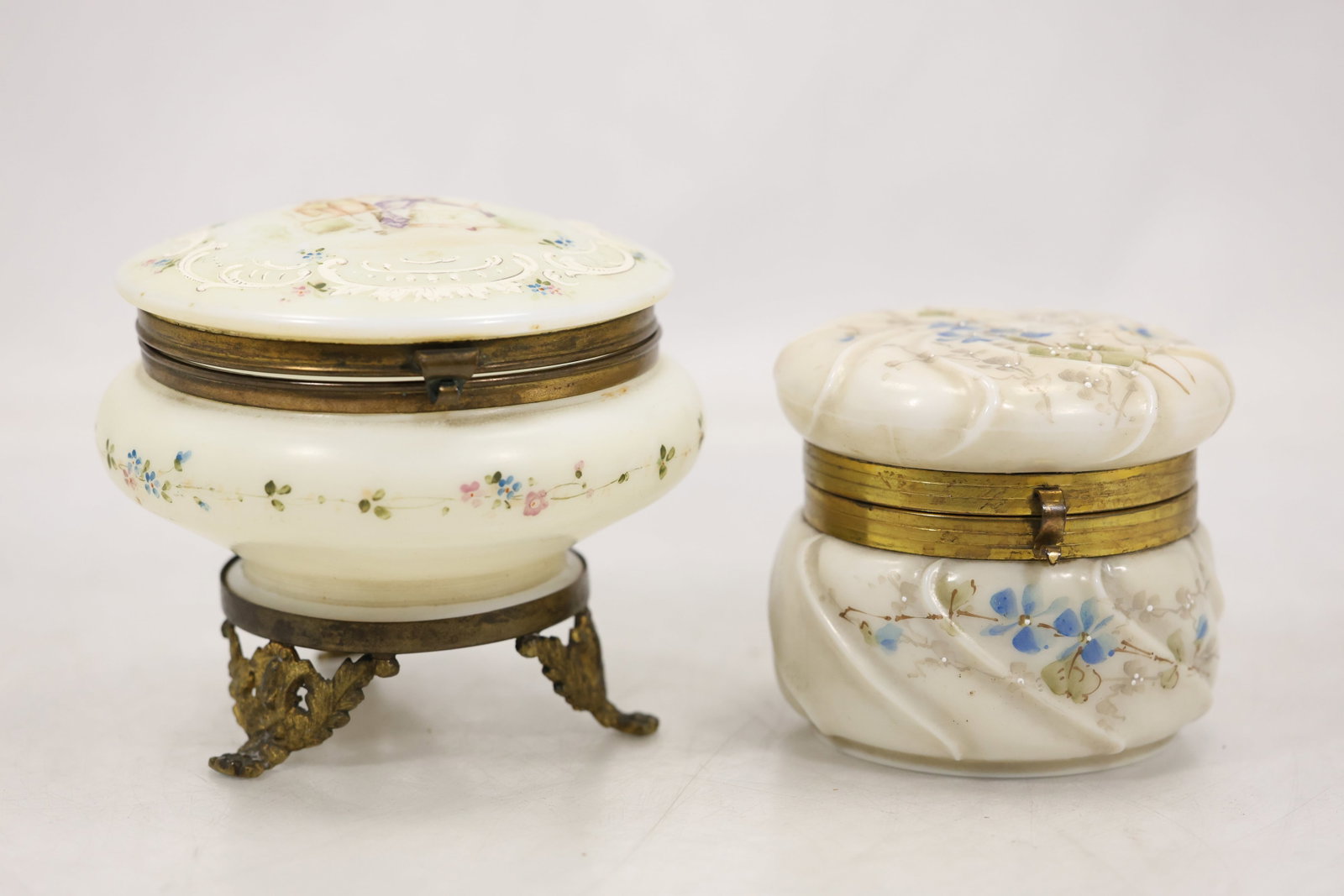 Pair of Victorian Style Dresser Jewelry Boxes – Floral Design: Two decorative dresser or jewelry boxes in a Victorian style, each featuring a softly shaped body with delicate floral decoration. Both have hinged lids with brass-tone mounts and clasps, adding a nic