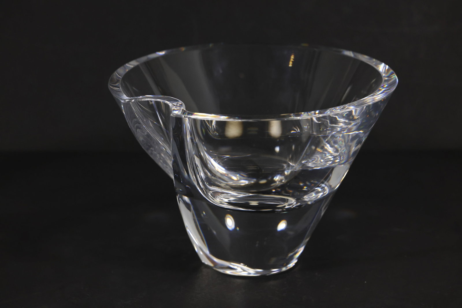 Signed Goran Wärff for Kosta Boda Glass Bowl – Sculptural Fruit Bowl: Art glass bowl designed by Göran Wärff for Kosta Boda, featuring a thick, sculptural clear glass form with a fluid, asymmetrical rim and integrated handle detail. The design emphasizes movement and 