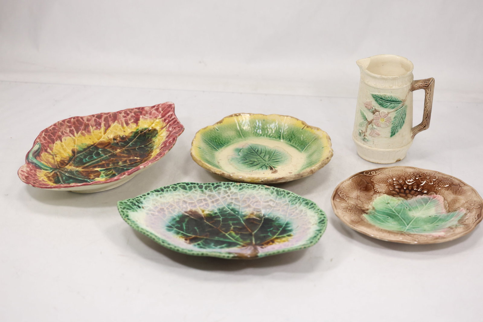 5 Assorted Pottery Leaf Plates and Mug: 5 Assorted Pottery Leaf Plates and Mug size: 2h 12w S:C** Important Auction information:**** All lot descriptions in this auction were generated using artificial intelligence piloting innovative techn