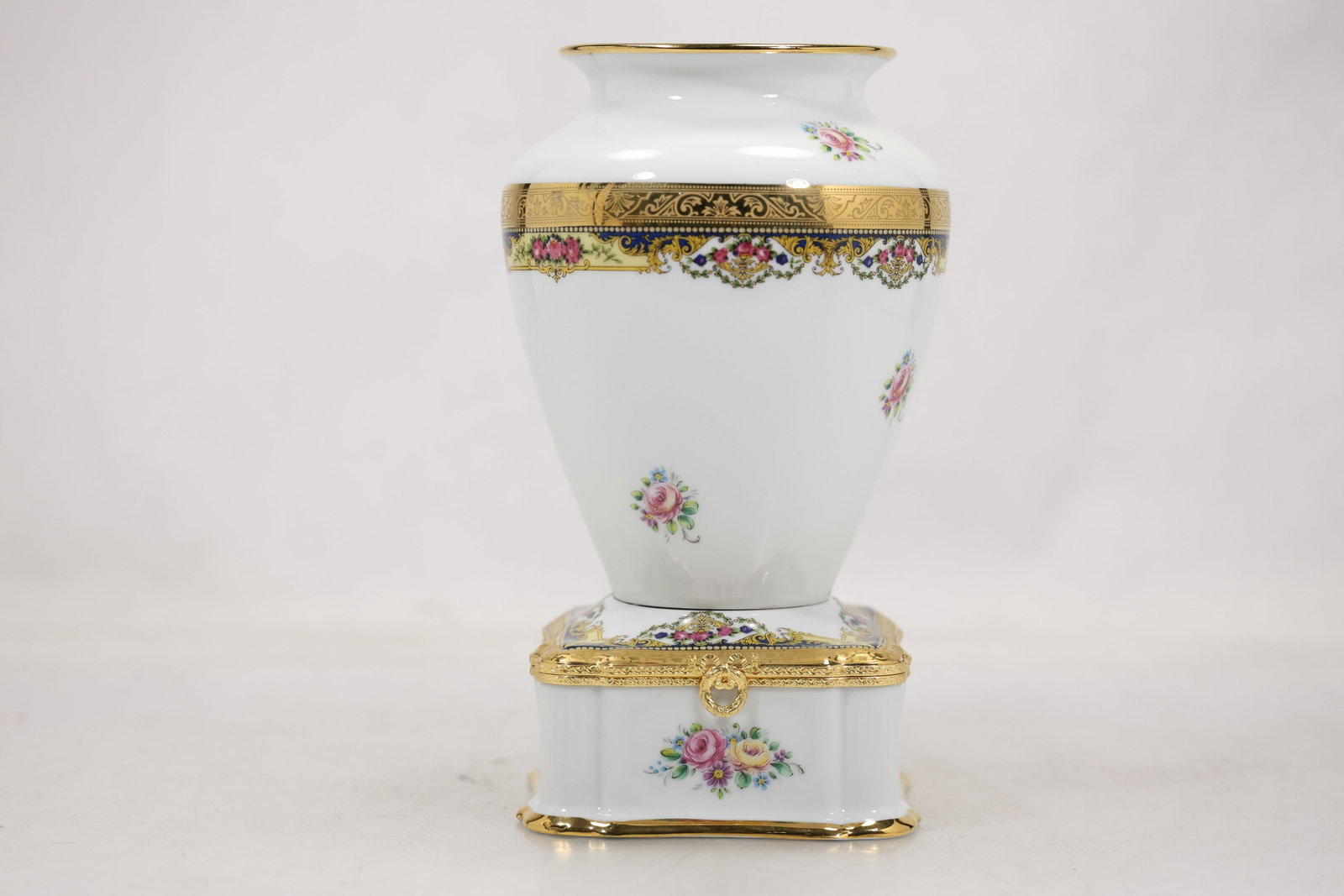 Pair of Limoges Porcelain Decorative Vessel and Covered Trinket Box: Elegant pair of French Limoges porcelain decorative pieces comprising a floral urn-form vase and matching hinged trinket box. Each features a bright white ground accented with hand-applied floral bouq