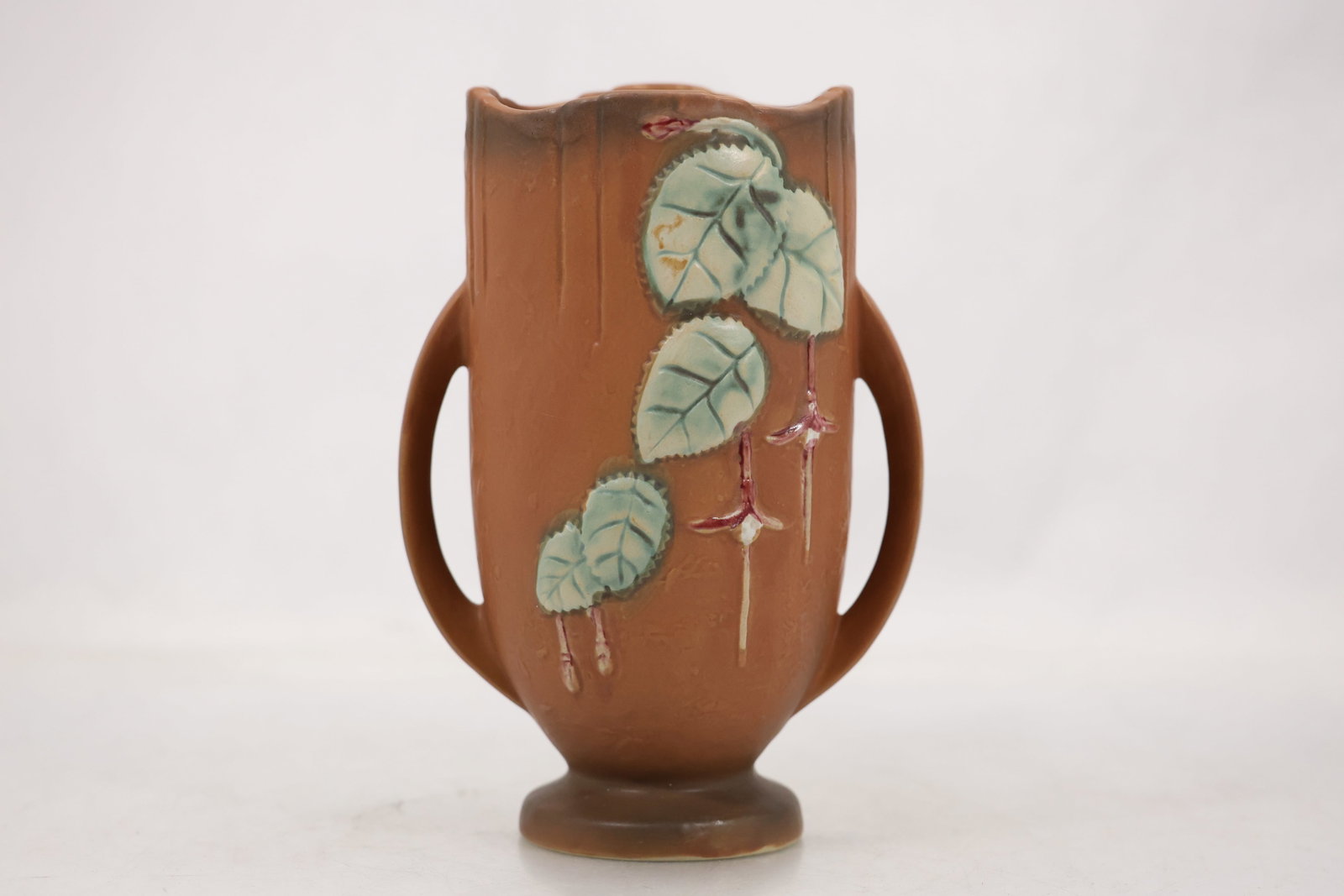 Roseville 8-968 Pottery Double Handled Nasturtium Vase: American art pottery vase featuring a warm brown matte glaze with applied stylized nasturtium leaves and blossoms. The vessel has twin side handles and a scalloped rim. Impressed factory marks to unde