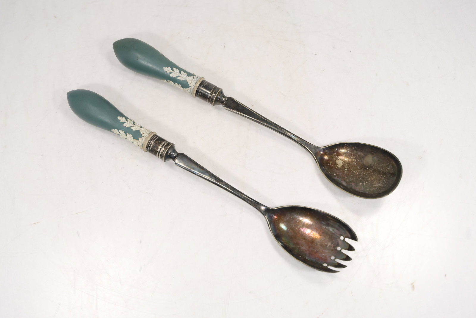 Silverplate Salad Servers With Jasperware Style Handles: Pair of serving utensils including one large spoon and one pierced serving fork or salad fork. Each piece has a silver tone metal bowl and stem with a teal green handle decorated with white applied ne