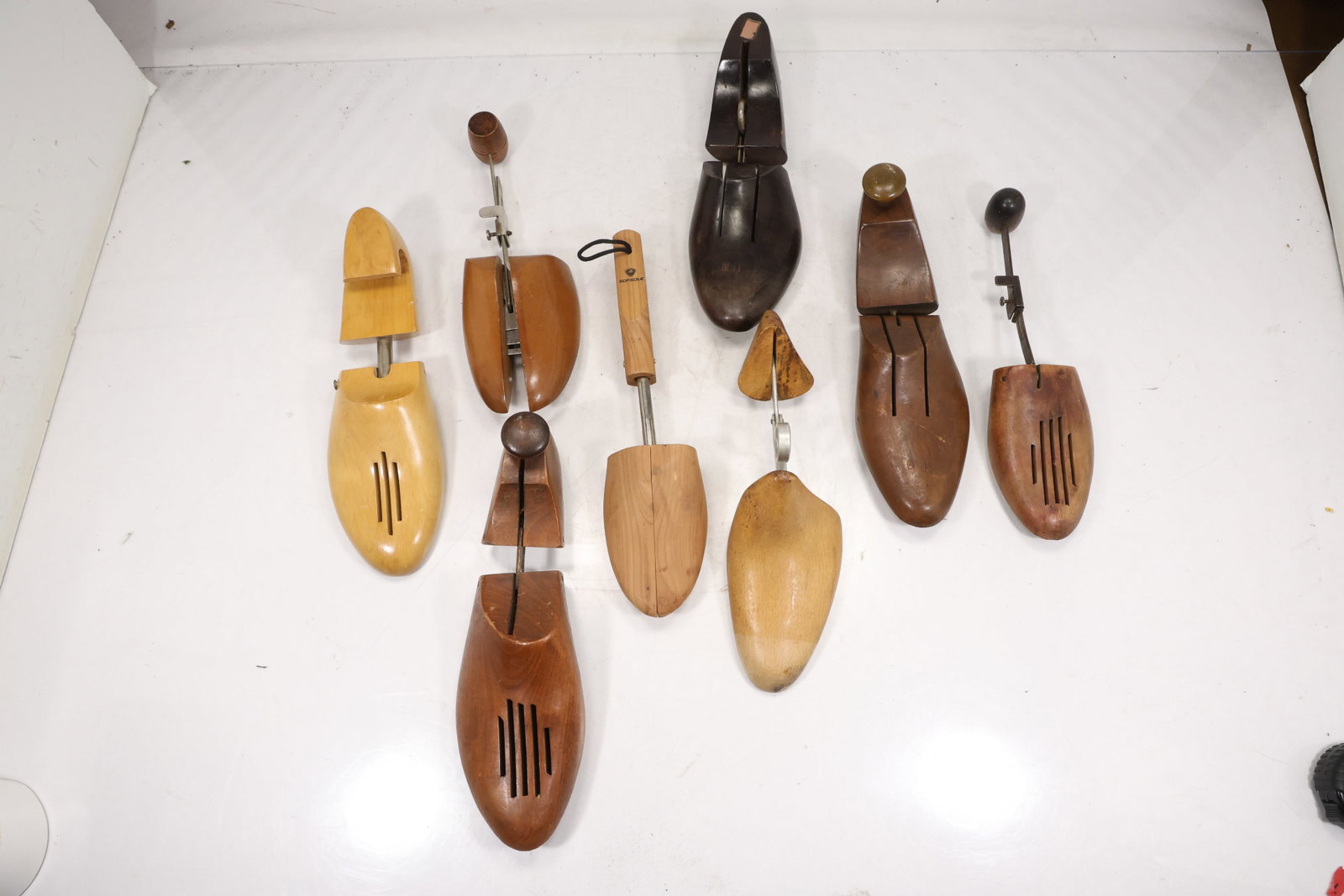 Assorted Wooden Shoe Trees and Shoe Care Accessories: Group of assorted wooden shoe trees shoe stretchers and shoe care accessories in varied hardwood tones. The collection includes split toe forms spring loaded mechanisms metal shafts and long handled