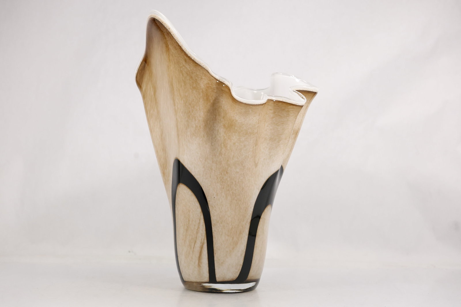 Large Black and Beige Sculptural Studio Pottery Vase: Large sculptural ceramic vase with tall tapering body irregular folded rim and cream beige glaze overlaid by sweeping black graphic bands. The interior is white glazed and the underside appears unmark