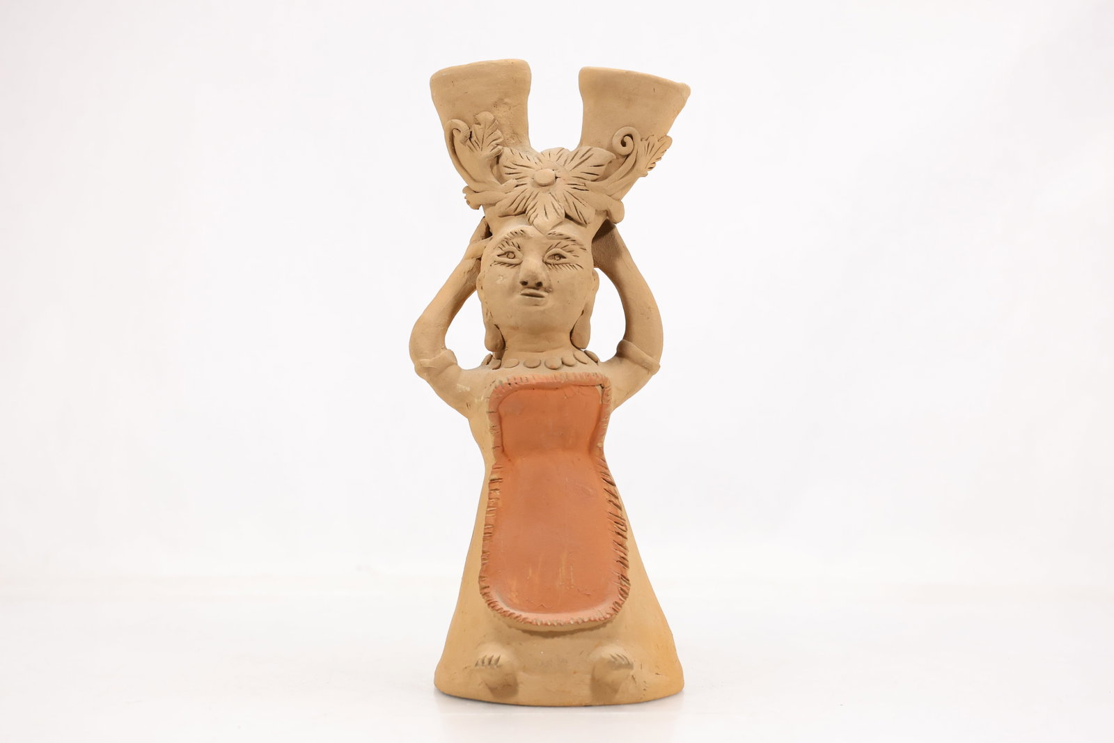 Folk Art Terracotta Figural Candleholder: Hand-crafted terracotta figural sculpture depicting a stylized female figure supporting a double-spouted architectural form above her head. Executed in a naïve folk art style with floral hair decorat