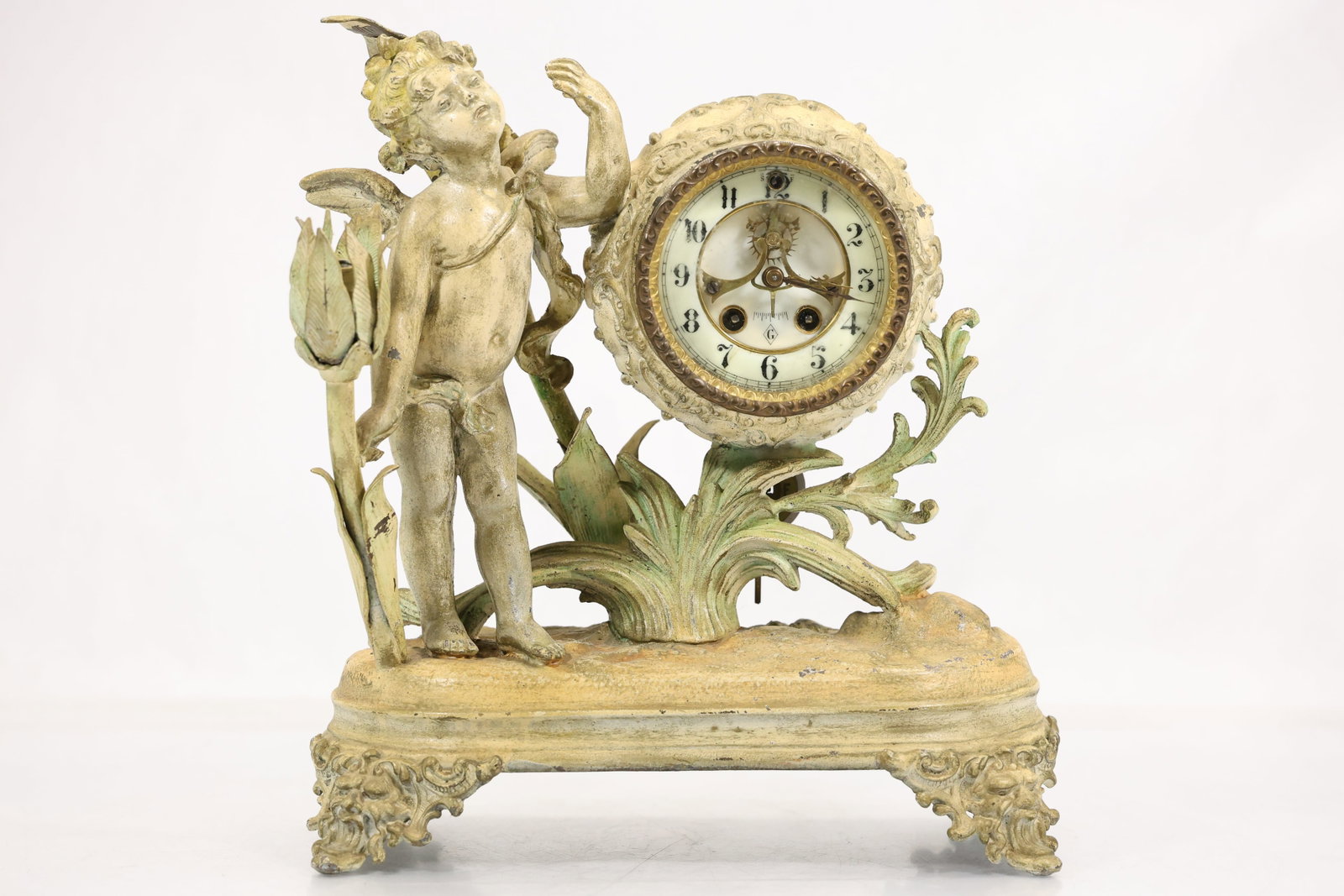 Wm L Gilbert Figural Cherub Mantel Clock: - - Figural mantel clock marked Wm L Gilbert Clock Co Winsted Conn USA on the interior backplate with number 18389 stamped above. The clock has a cream painted and gilt tone cast metal case with a sta