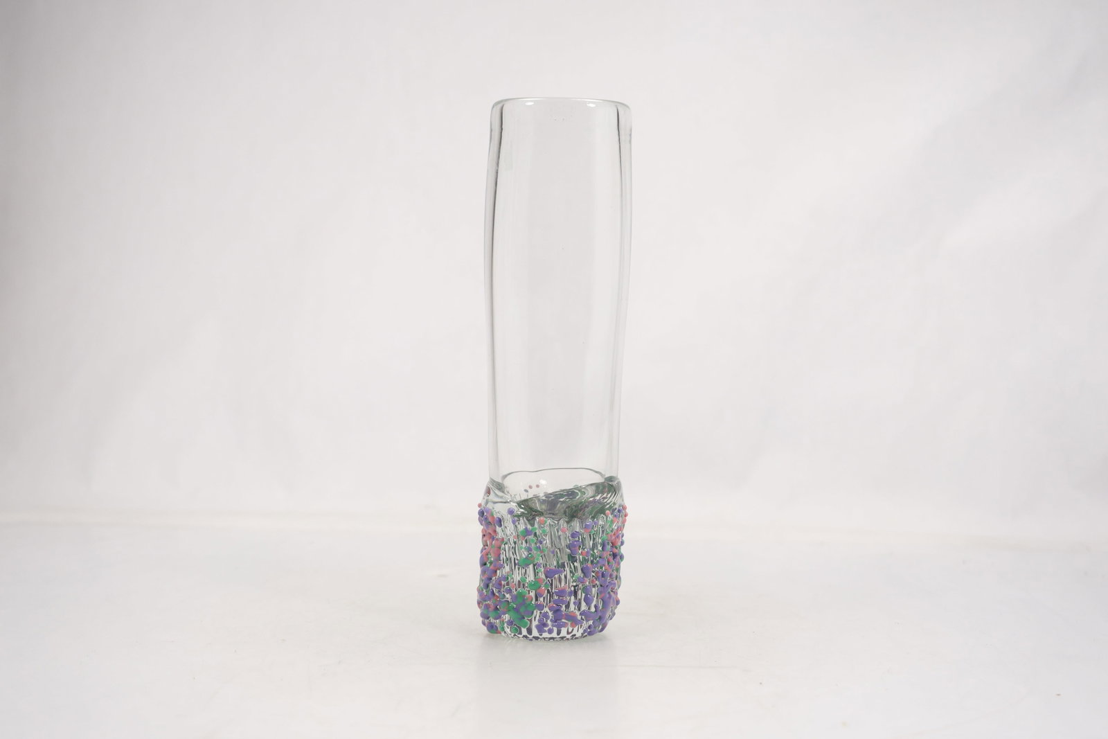 Signed Studio Art Glass Cylinder Bud Vase: Tall clear cylindrical studio art glass vase with an applied textured base in purple green and pink glass. An etched signature and date appear on the underside but the maker is not confirmed. The