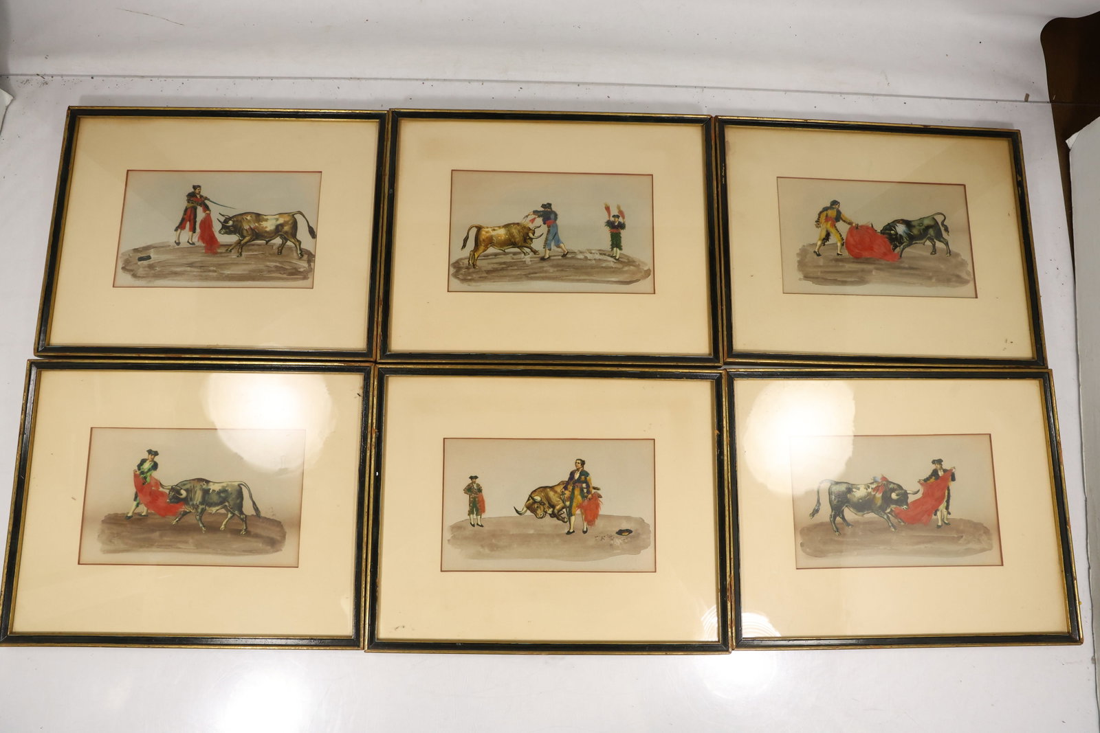 Set of Six Framed Hand Colored Spanish Bullfighting Prints: Set of six hand colored prints depicting Spanish bullfighting scenes with matadors bulls mounted figures and arena action. Each print is presented under glass in an individual frame. The images measur