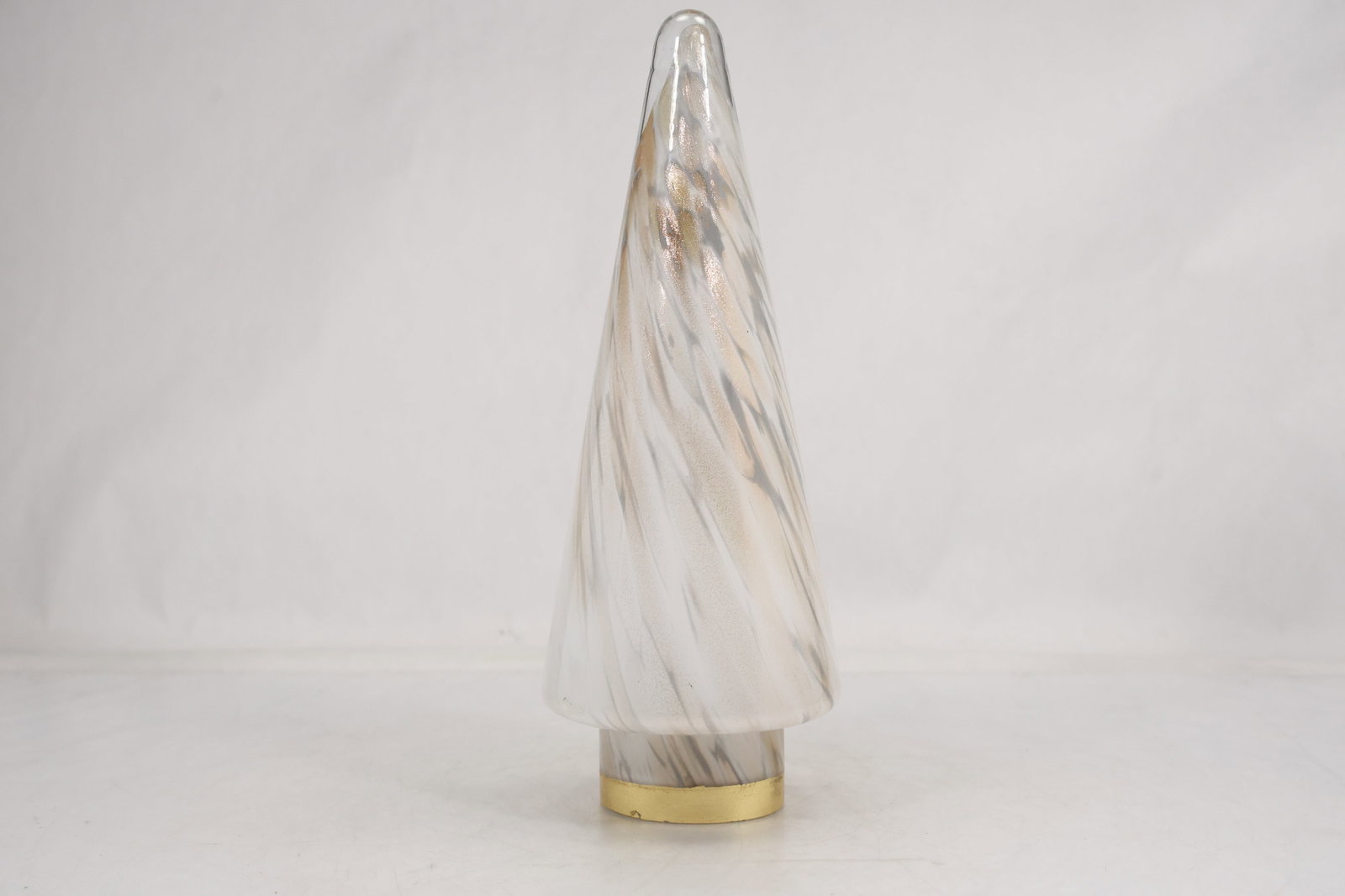 Clear Art Glass Christmas Tree Sculpture: Clear art glass Christmas tree sculpture with a tall tapered profile internal spiral texture and a small gold tone circular base. The transparent form is unmarked in the photographed views and is cata