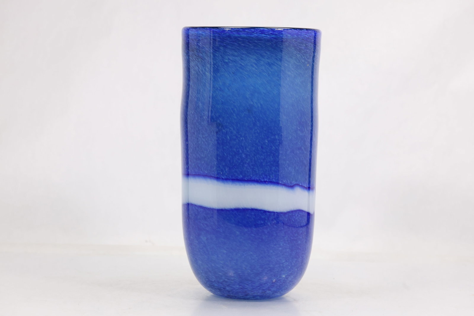 Cobalt Blue and White Stripe Art Glass Vase: Tall cylindrical art glass vase in saturated cobalt blue with a single horizontal white band around the body. The vessel has a rounded base straight walls and a simple open rim. No maker mark or label