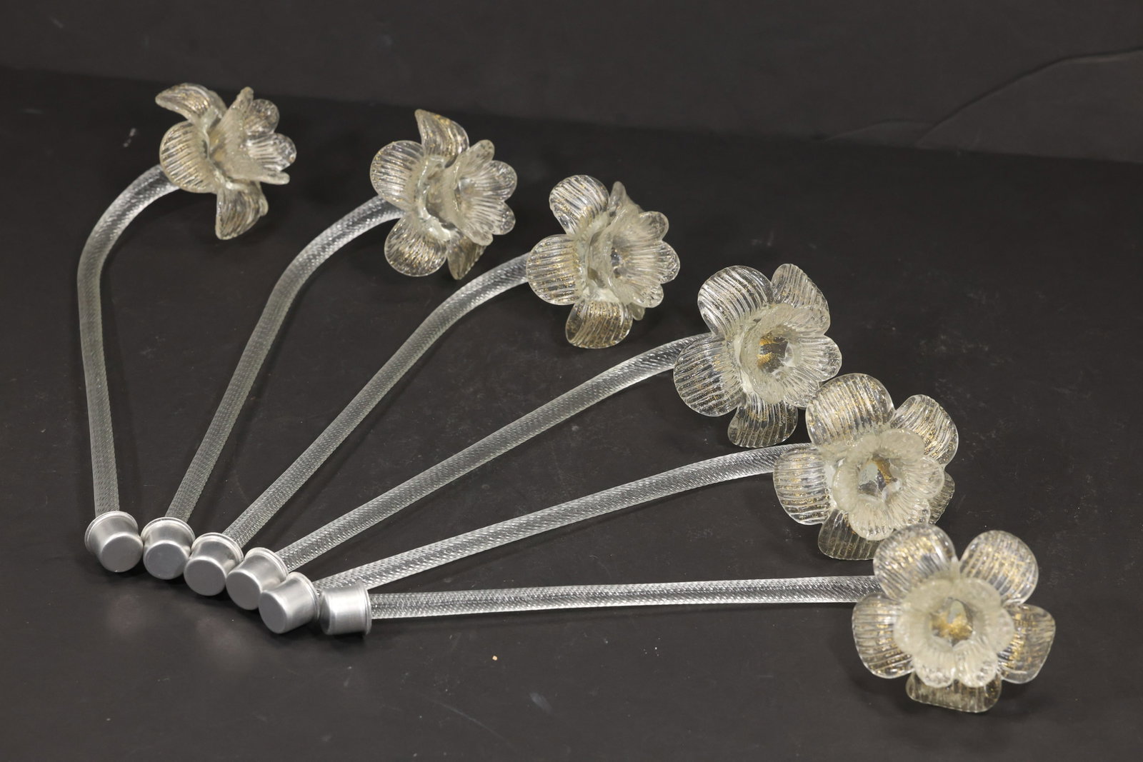 Set of Six Clear Murano Glass Flower Chandelier Stems: Set of six vintage mid century Murano glass clear flower chandelier stems from confirmed importer stock. Each curved clear support ends in a textured translucent blossom with layered petals and a pale