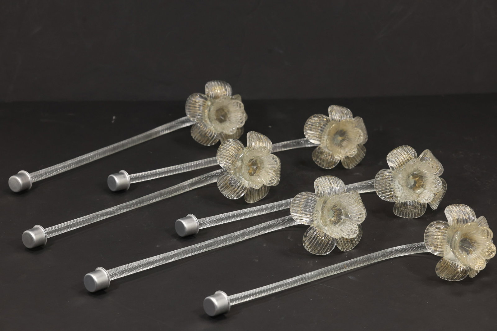 Set of Six Clear Murano Glass Flower Chandelier Stems: Set of six vintage mid century Murano glass clear shimmering flower chandelier stems from confirmed importer stock. Each curved support terminates in a layered blossom with textured petals and a clear