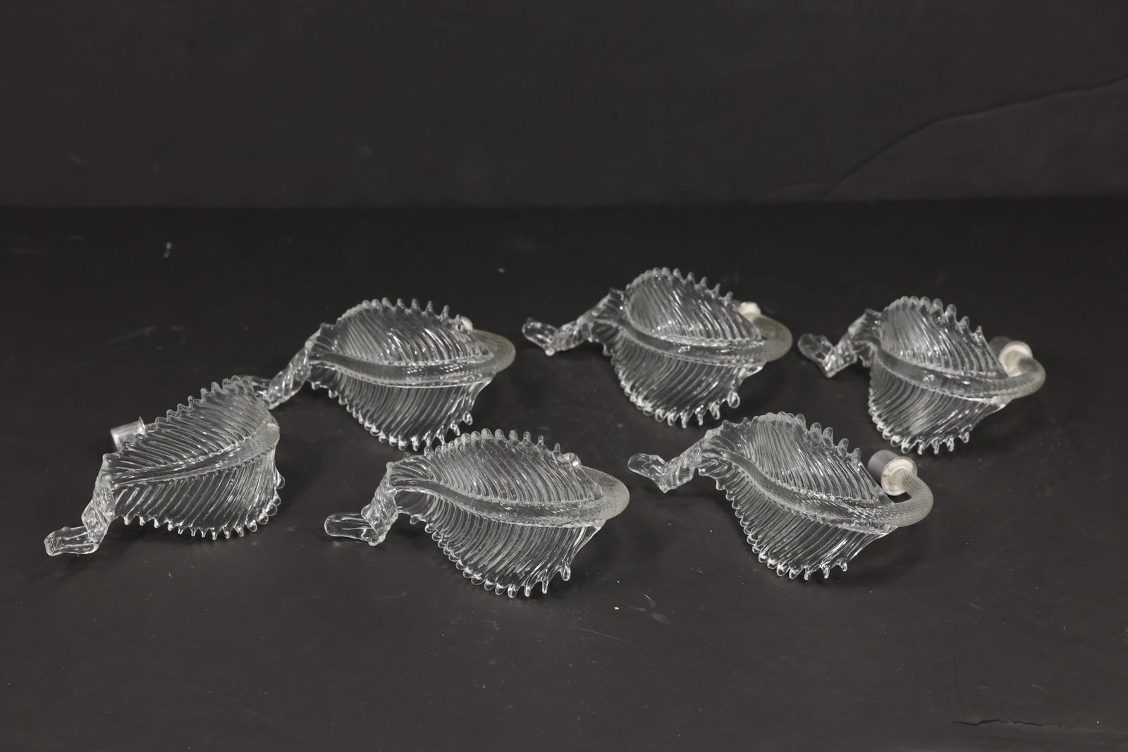 Set of Six Clear Murano Glass Leaf Chandelier Parts: Set of six vintage mid century Murano glass clear foliage chandelier replacement parts from confirmed importer stock. Each short element has a curved stem ribbed leaf body serrated edge and transparen