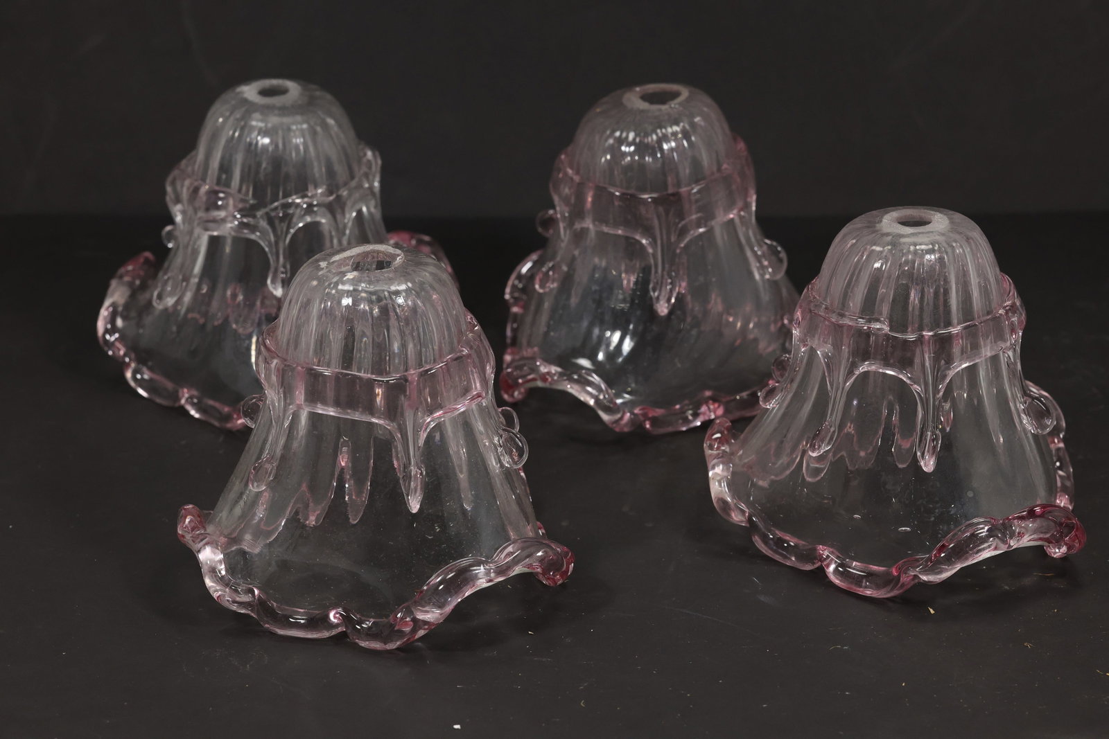 Set of Four Pink Tip Murano Glass Bell Chandelier Shades: Set of four vintage mid century Murano glass clear and pink bell chandelier shades from confirmed importer stock. Each shade has a vertically ribbed body domed crown and petal rim with rose colored ac