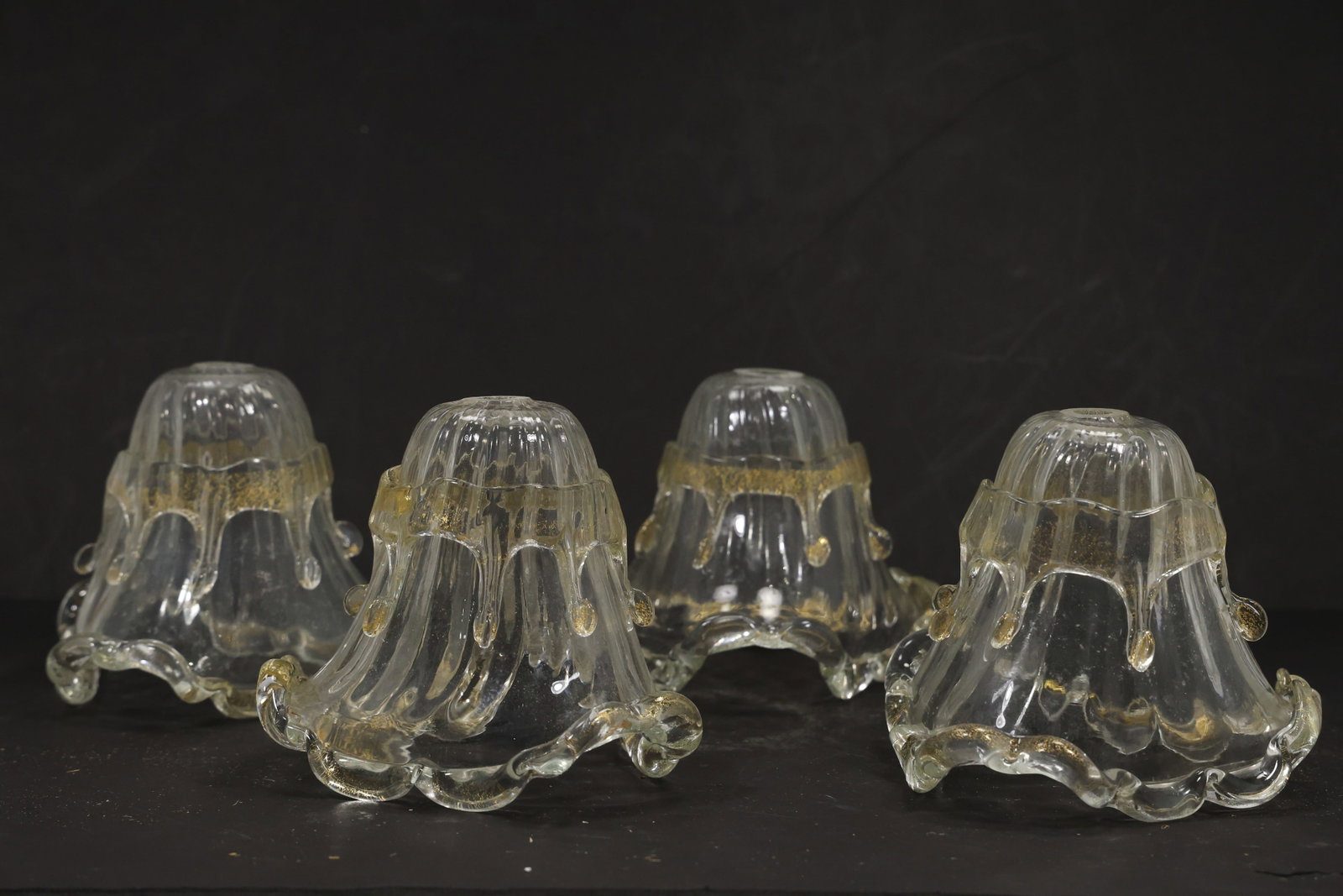 Set of Four Gold Fleck Murano Glass Bell Chandelier Shades: Set of four vintage mid century Murano glass clear gold shimmer bell chandelier shades from confirmed importer stock. Each compact shade has a scalloped petal rim ribbed body and warm metallic inclusi