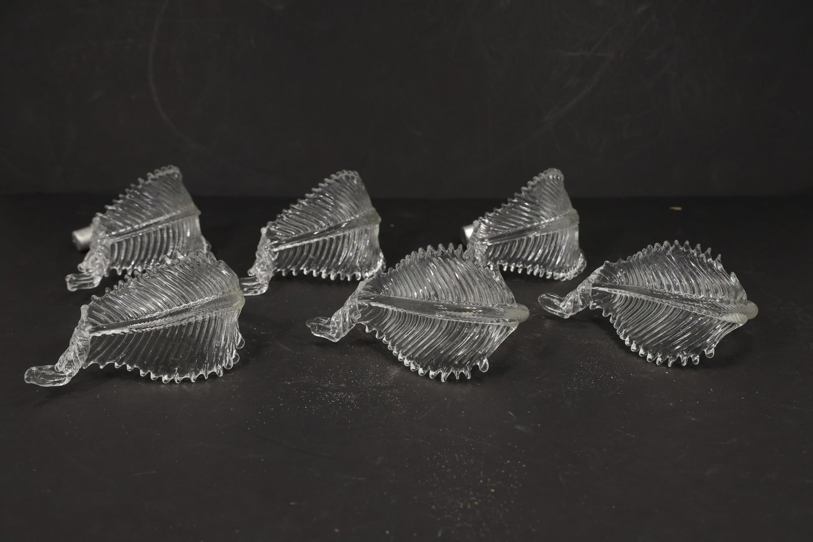Set of Six Clear Murano Glass Leaf Chandelier Parts: Set of six vintage mid century Murano glass clear foliage chandelier replacement parts from confirmed importer stock. Each compact curved element has a ribbed leaf body serrated edge and transparent c