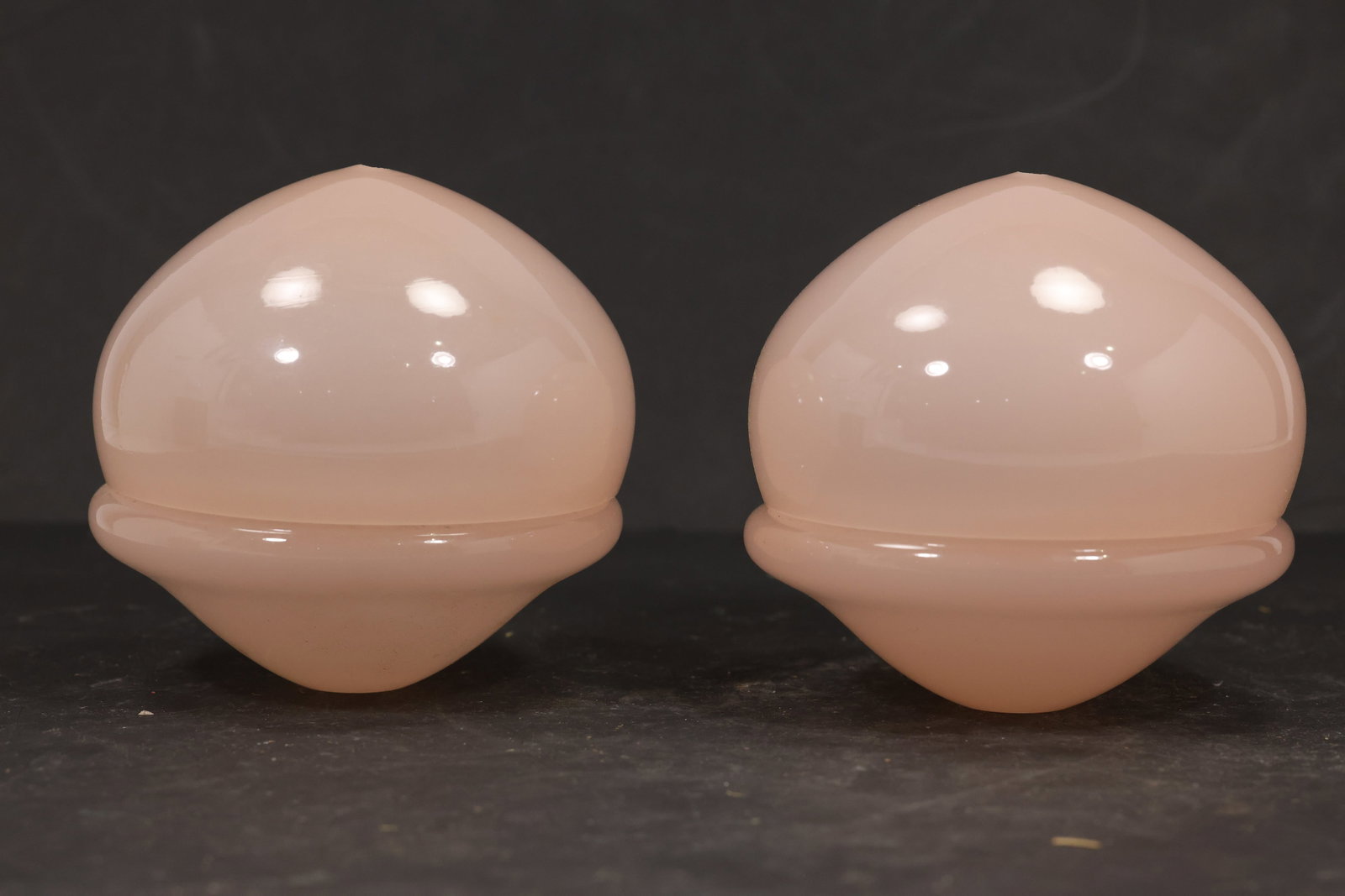 Pair Pink Murano Glass Domed Chandelier Covers: Pair of vintage mid century Murano glass rounded domed chandelier covers from confirmed importer stock. Photographs show smooth spherical bodies with raised equatorial ribs and open undersides in pink