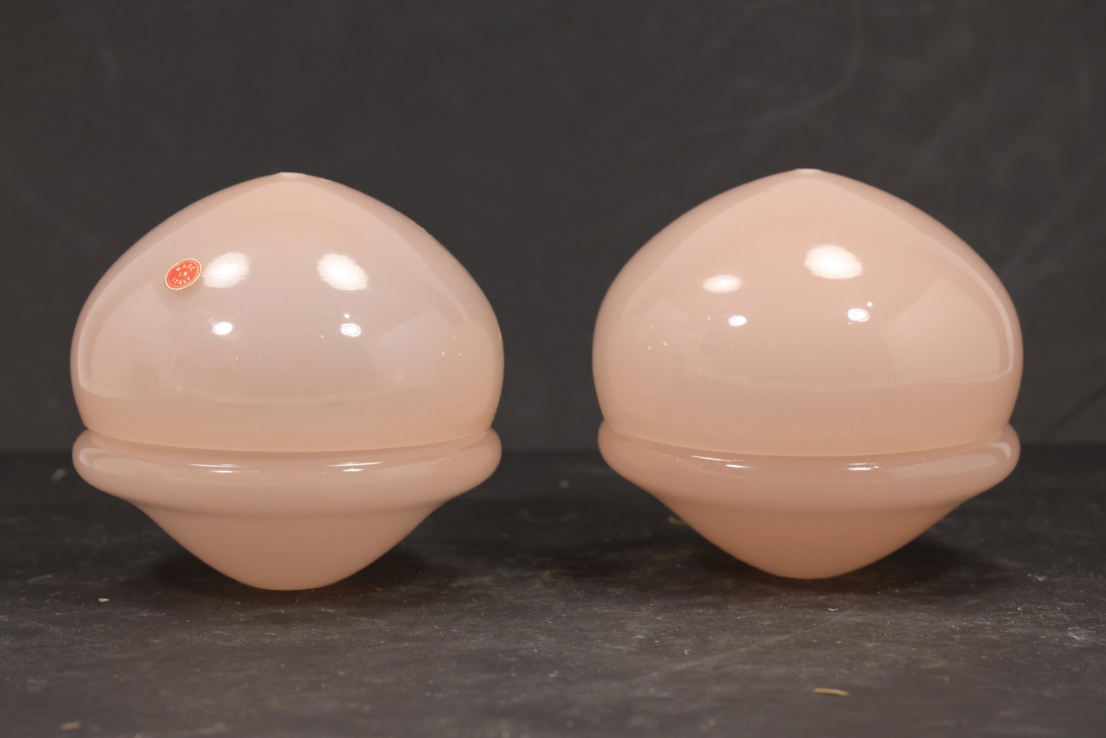 Pair Pink Murano Glass Domed Chandelier Covers: Pair of vintage mid century Murano glass rounded domed chandelier covers from confirmed importer stock. Photographs show smooth spherical bodies with raised equatorial ribs and open undersides in pink
