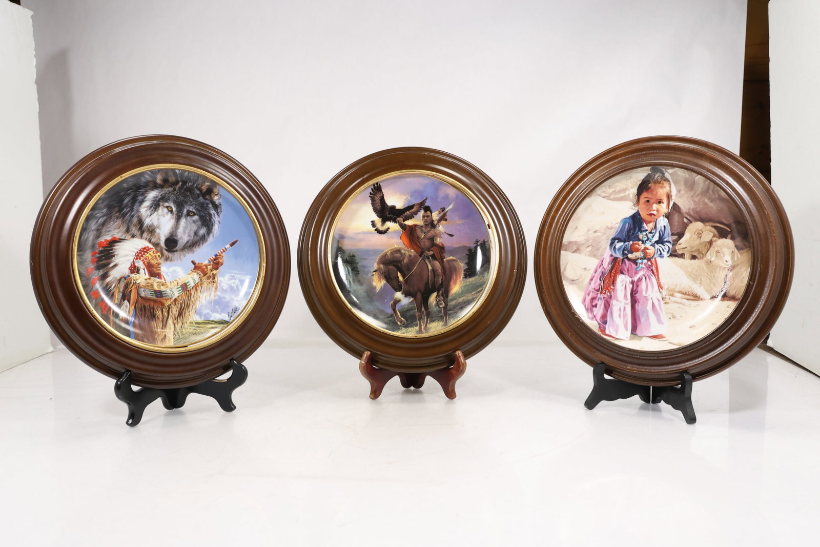 Three Framed Limited Edition Franklin Mint & Hamilton Collection Collector Plates: Collection of three limited-edition decorative collector plates featuring Native American and Western-themed artwork, each mounted in a round wooden display frame. Included are "Summoning of the Wolf 