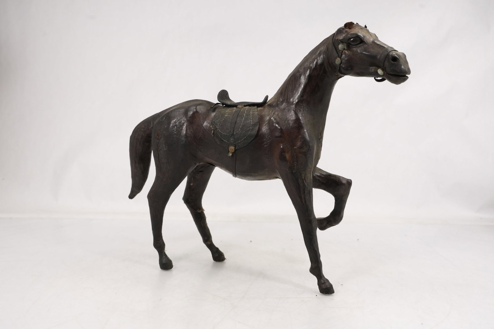 Large Leather Horse Statue – Handcrafted Sculptural Figure: Decorative horse statue crafted in leather over a formed structure, featuring a dynamic standing pose with one front leg raised. The surface shows stitched and paneled leather construction, giving it 