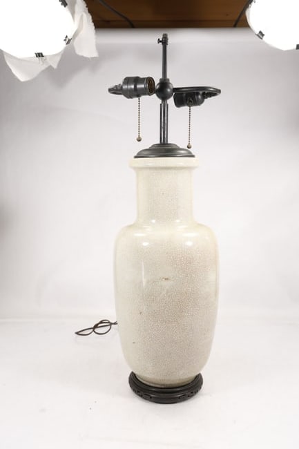 White Crackle Glaze Porcelain Vase Form Double Socket Table Lamp: White glazed porcelain vase form table lamp with an allover fine gray crackle pattern. The rounded baluster body has a short neck and is mounted between dark metal fittings and a carved Asian style wo