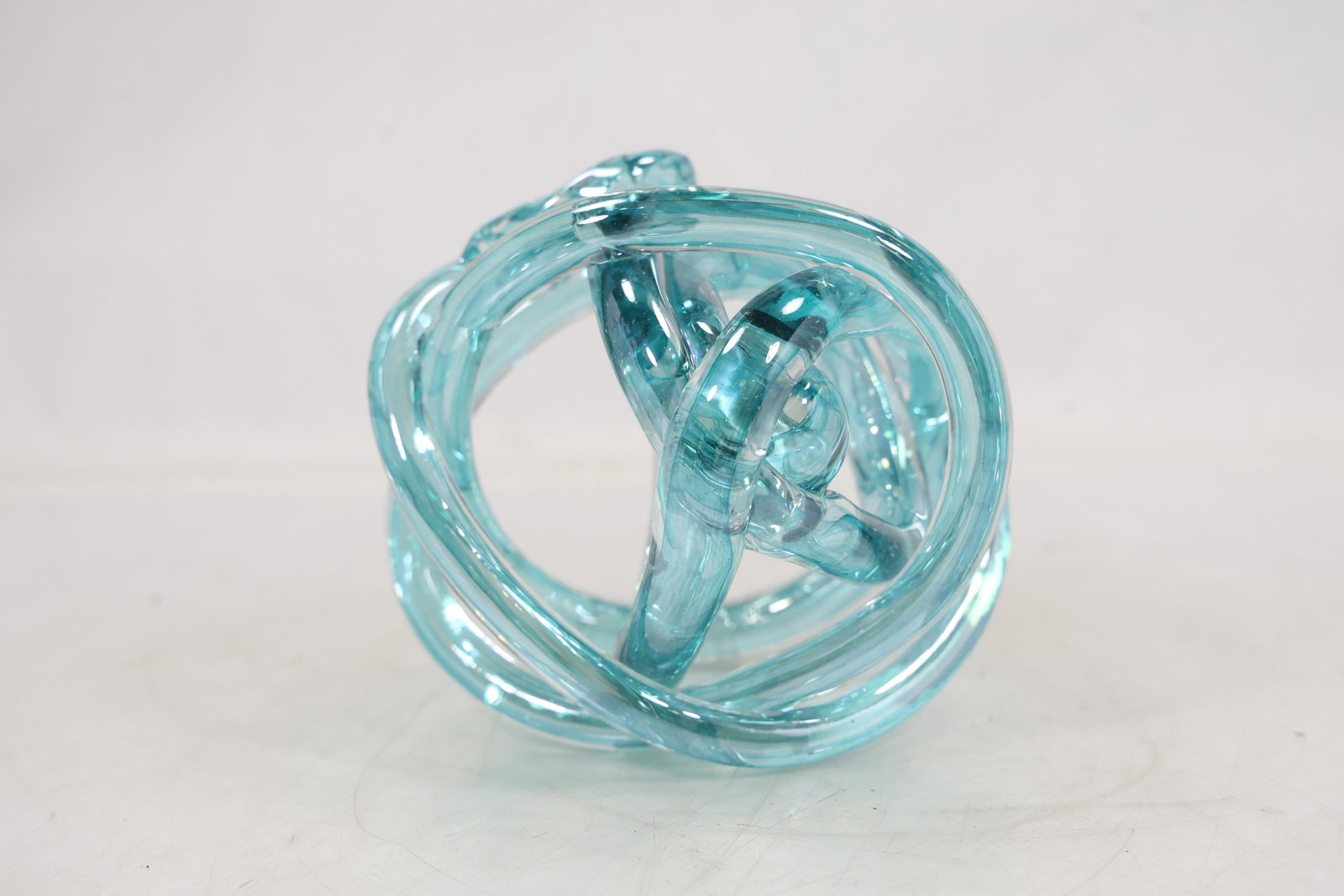 Turquoise Blue Glass Knot Sculpture: Turquoise Blue Glass Knot Sculpture size: 5h 6w S:G** Important Auction information:**** All lot descriptions in this auction were generated using artificial intelligence piloting innovative technolog