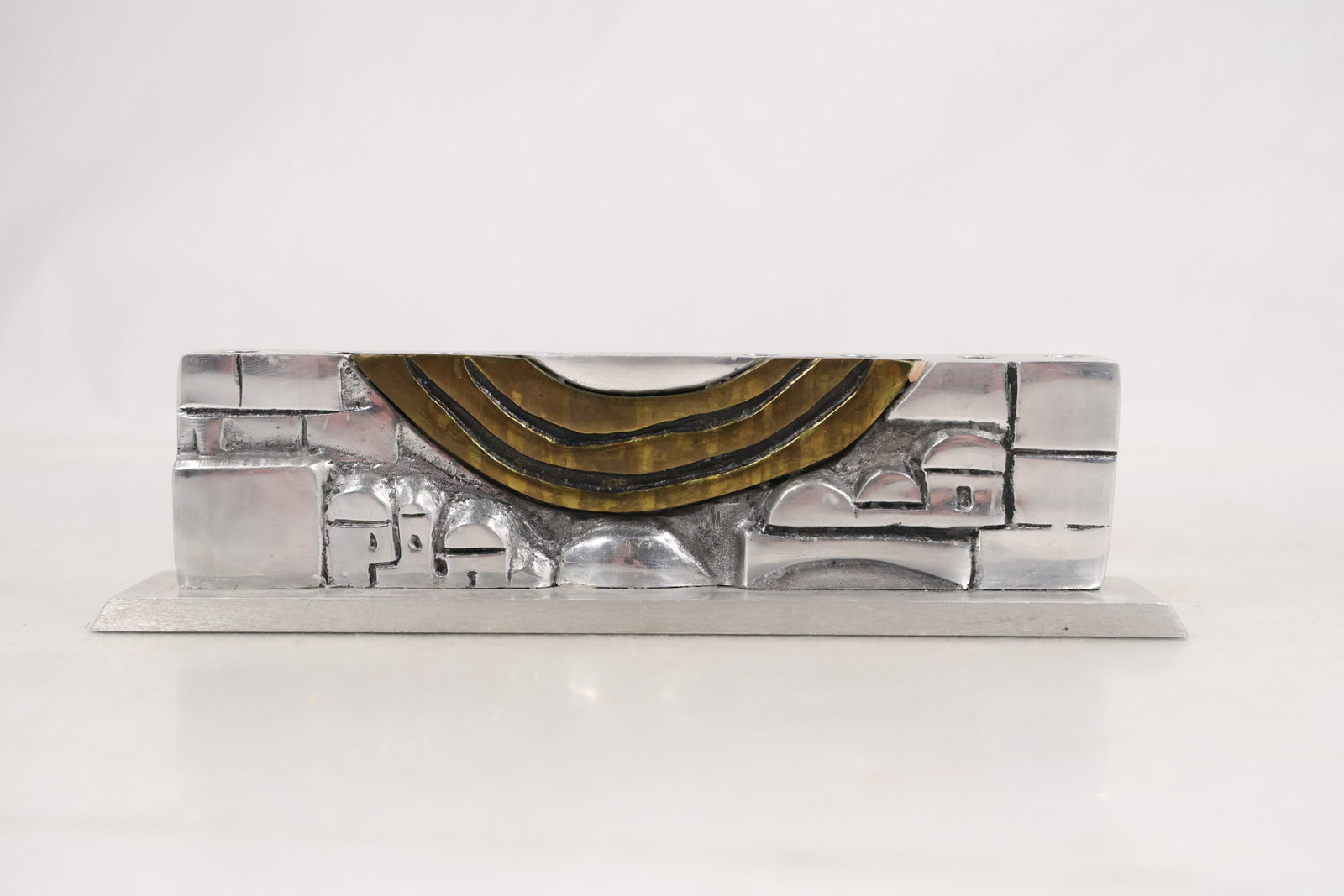 Avi Soffer Gallery Old Jaffa Israel Mixed Metal Modernist Sculpture: Abstract modernist sculpture constructed from mixed metals and mounted on a rectangular black base. The composition incorporates textured geometric forms and curved brass tone elements arranged in a r