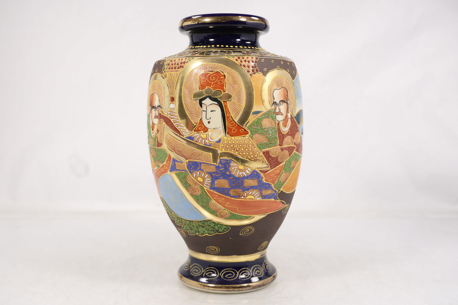 Japanese Satsuma-Style Porcelain Vase with Figural Decoration: Japanese porcelain vase decorated in the Satsuma style, featuring richly detailed figural scenes accented with gilt and polychrome enamels. The composition shows traditionally dressed figures set agai