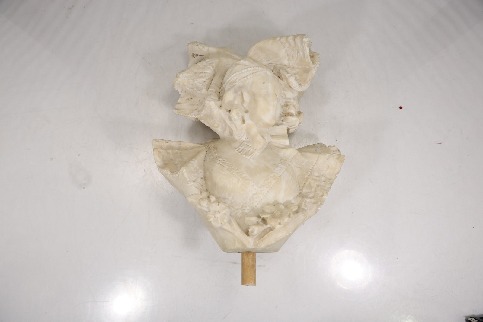 19th Century Carved Alabaster Female Bust Sculpture in the Manner of Carrier Belleuse: Carved bust sculpture depicting a young female figure with head inclined downward, wearing an elaborate bonnet and lace detailed bodice. The composition features finely modeled facial features, layere