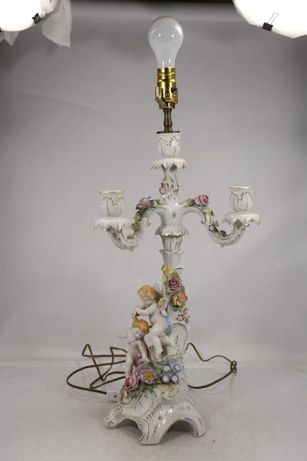 German Von Schierholz Porcelain Candelabrum Lamp: Highly detailed porcelain candelabrum lamp attributed to Von Schierholz, featuring an ornate figural design with a cherub surrounded by applied floral elements. The structure is formed as a multi-arm 