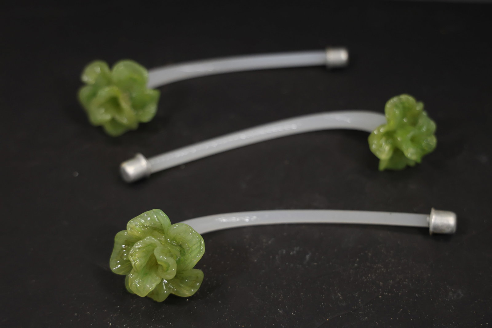 Set of Three Green and White Murano Glass Flower Chandelier Stems: Set of Three vintage mid century Murano glass flower chandelier stems from confirmed importer stock. Photographs show curved or straight supports ending in layered blossoms with modeled petals in gree