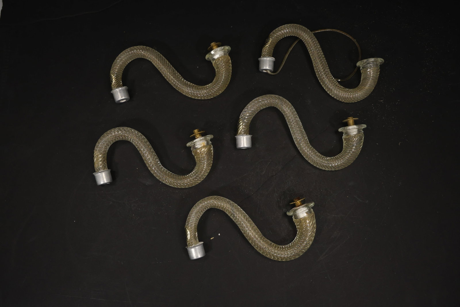 Set of Five Clear Gold Fleck Murano Glass Curved Chandelier Arms: Set of Five vintage mid century Murano glass curved chandelier arms from confirmed importer stock. Photographs show S shaped glass bodies with metal fittings at the ends in clear gold fleck tones. Sui