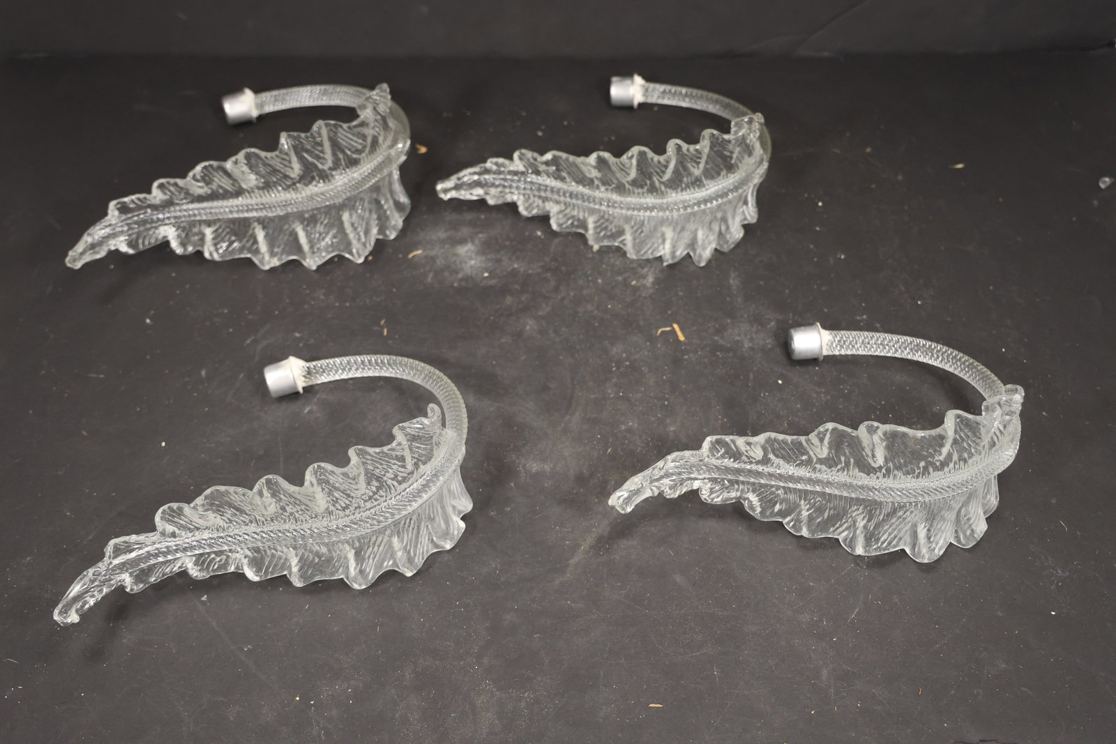 Set of Four Clear Murano Glass Leaf Chandelier Stems: Set of Four vintage mid century Murano glass foliage chandelier stems from confirmed importer stock. Photographs show ribbed leaf bodies with serrated edges and mounting ends in clear tones. Suitable 