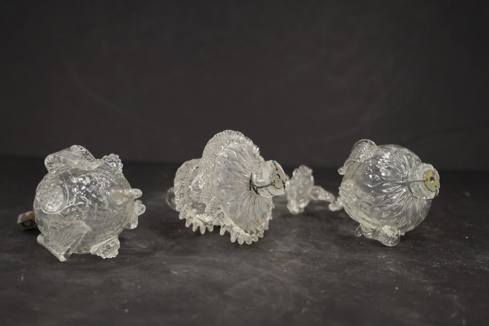 Set of Three Clear Murano Glass Chandelier Bottom Finials: Set of Three vintage mid century Murano glass chandelier bottom finial or lower decorative element from confirmed importer stock. Photographs show a sculpted body with central fitting for a chandelier