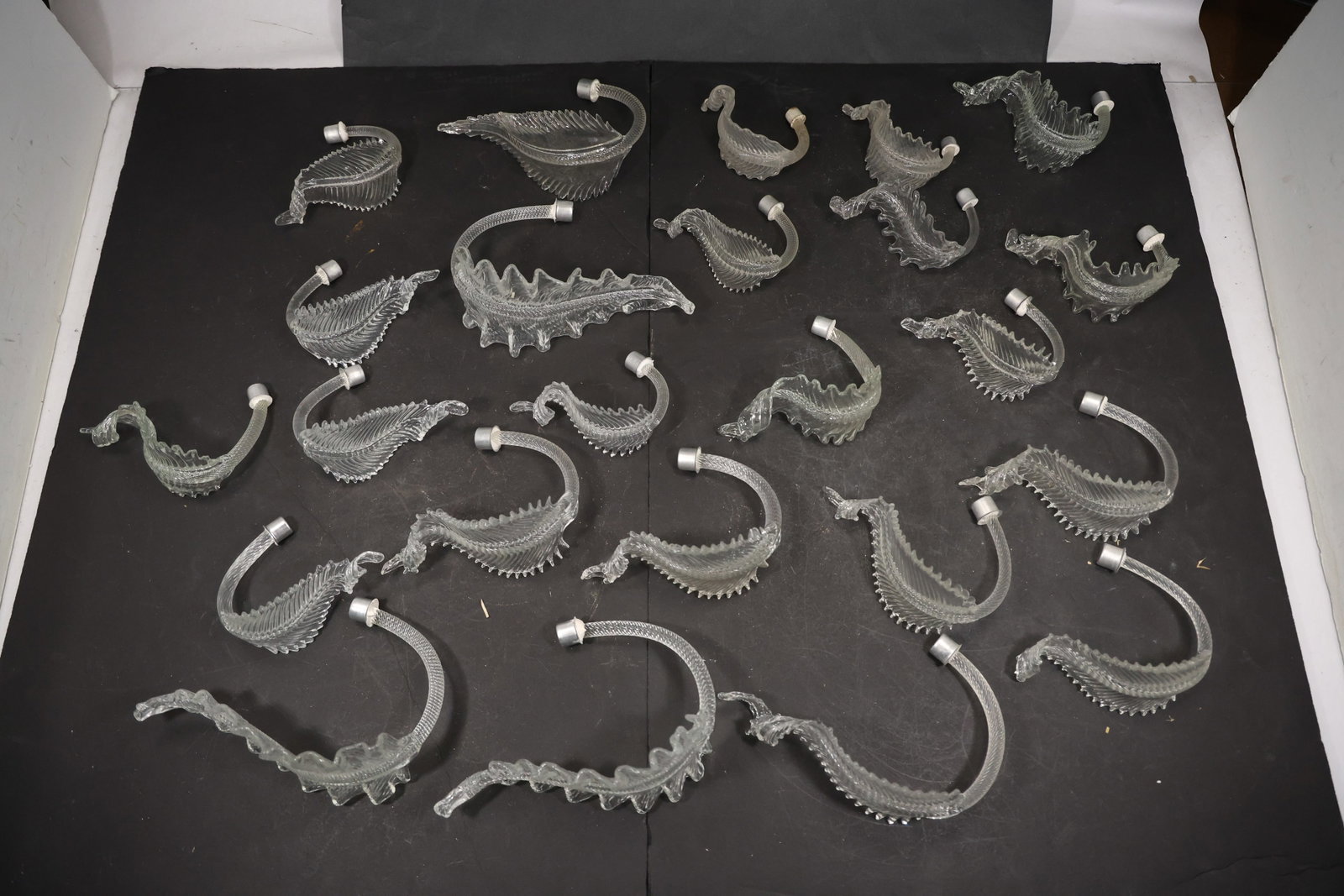 Set of Twenty Four Clear Murano Glass Leaf Chandelier Stems: Set of Twenty Four vintage mid century Murano glass foliage chandelier stems from confirmed importer stock. Photographs show ribbed leaf bodies with serrated edges and mounting ends in clear tones. Su