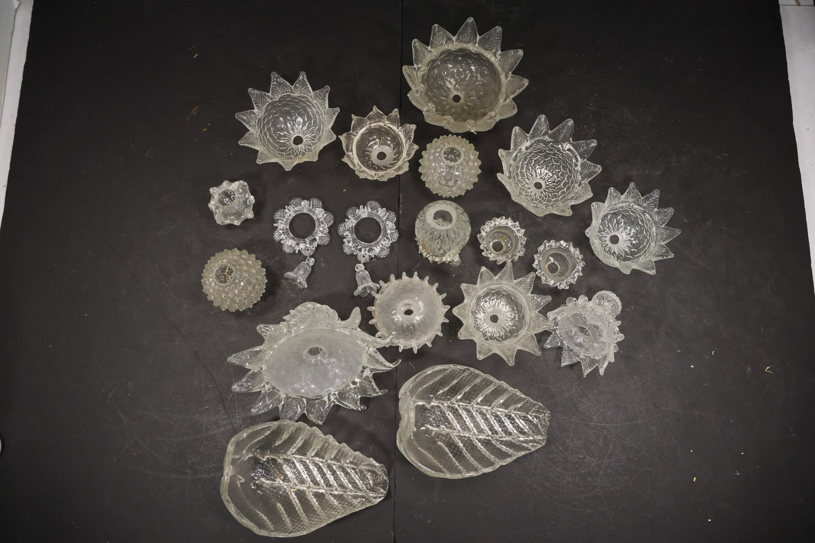 Set of Nineteen Clear Murano Glass Mixed Chandelier Parts: Set of Nineteen vintage mid century clear Murano glass chandelier restoration parts from confirmed importer stock. Photographs show an assorted group of flower shades bobeches leaves and molded decora