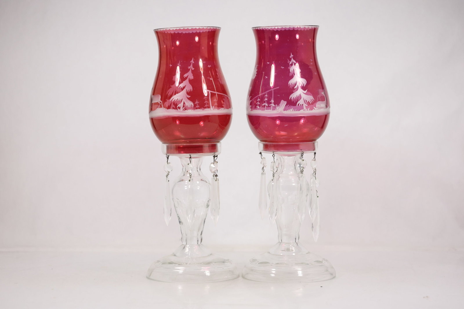 Pair Ruby Glass Hurricane Lamp Shades: Photographs show pair ruby glass hurricane lamp shades with decorative glass or ceramic elements and metal fittings. The form hardware colors and component count are described from the visible images 
